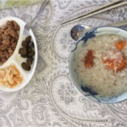 Beautiful guest breakfast submission, appears to be coconut flakes, persimmon, wheat porridge