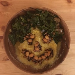 Pumpkin cornmeal porridge with roasted seeds, peanuts, and greens